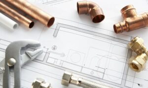 VVS-verktyg och kopparrör läggs ut ovanpå arkitektritningar och bygglovsritningar online.
